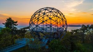 a large metal object with the sunset in the background at Villa-Negra Retro Panzió in Balatonföldvár