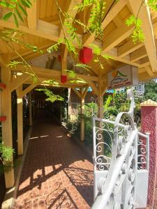a wooden walkway with a bench under a wooden structure at Appartement charmant à Pointe-Noire - Piscine et Jacuzzi - 54 m² in Pointe-Noire
