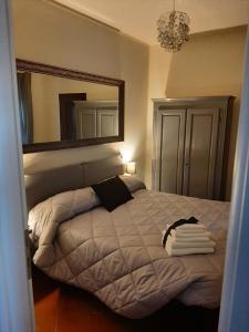 una camera da letto con un letto e un grande specchio di B&B Principe Calaf 3 a Lucca