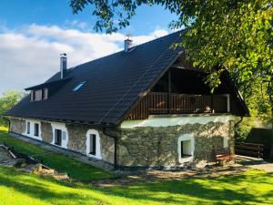 uma casa de pedra com um telhado preto em Chalupa U sjezdovky, Zadov 22 em Stachy
