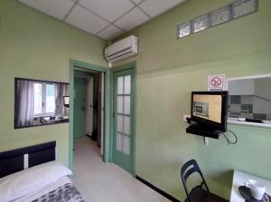 トリノにあるMonolocale Caraglioの壁にテレビとベッドが備わる客室です。