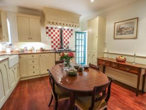 a kitchen with a wooden table and a wooden floor at Lion House in Newton Abbot