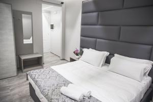 a bedroom with a large white bed with a black headboard at Correnti Boutique Hotel in Sanremo +9 photos