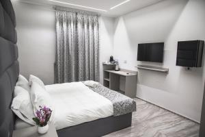 a bedroom with a bed and a flat screen tv at Correnti Boutique Hotel in Sanremo