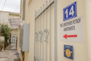 a building with a sign on the side of it with a door at The 3 Brothers' Apts in Chania Town