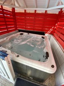 a jacuzzi tub in a room with red walls at Appartement moderne à Pointe-Noire - 36 m² - Piscine & Jacuzzi in Pointe-Noire +8 photos