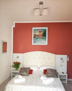 una camera con un letto bianco con una parete rossa di Golf & Beach Hotel B&B a Milano Marittima