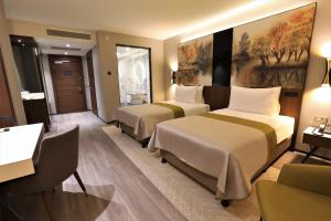 Postel nebo postele na pokoji v ubytování Limak Skopje Luxury Hotel