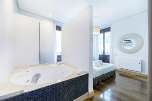 Habitación con baño con bañera y cama. en Madrid House Rooms, en Madrid