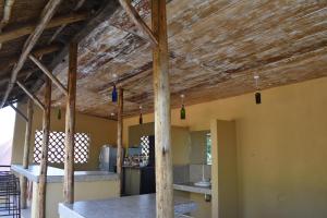 a kitchen with wooden ceilings and wooden beams at Secrets Guest House in Entebbe