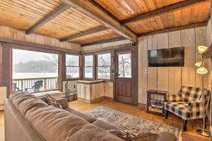 a living room with a couch and a flat screen tv at Lakefront Granby Escape with Private Dock and Kayaks! in Granby