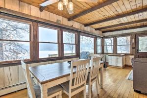 a dining room with a table and chairs and windows at Lakefront Granby Escape with Private Dock and Kayaks! in Granby