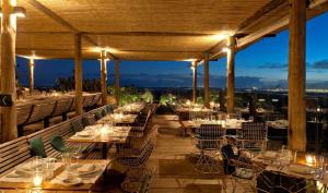 a restaurant with tables and chairs on a deck at night at Hotel Fasano Punta del Este in Punta del Este