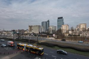 a bus driving down a highway in a city at Magnetic apartment Jerozolimskie A in Warsaw
