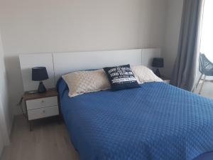 um quarto com uma cama azul com duas almofadas em Pacifico 802 em Arica