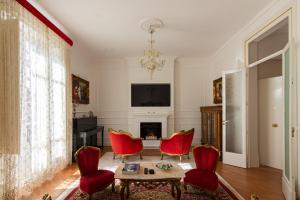 sala de estar con sillas rojas y chimenea en Le Rose di Nonna Maria, appartamento di lusso in centro città en Palermo