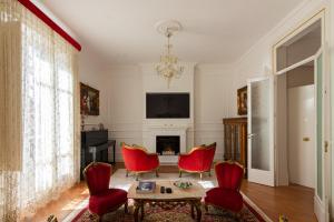 een woonkamer met rode stoelen en een open haard bij Le Rose di Nonna Maria, appartamento di lusso in centro città in Palermo