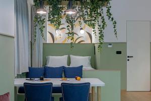 a dining room table with blue chairs and plants at Acro Urban Suites in Athens