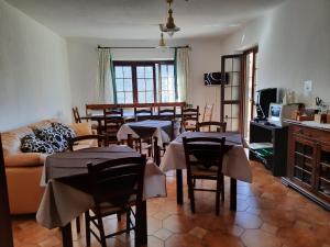 a living room with tables and chairs and a couch at Sa Stiddiosa Guesthouse in Gadoni