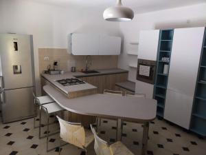 a kitchen with a table and chairs and a refrigerator at Sa Stiddiosa Guesthouse in Gadoni