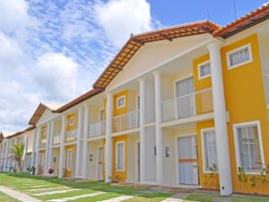 una fila de casas de color amarillo y blanco en Residencial Mont Hebron - Tonziro, en Porto Seguro