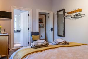 a bedroom with a bed with a mirror and a chair at The Mulberrys B&B in Downpatrick