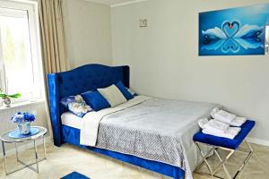 a bedroom with a blue bed and a table at Sieburczynianka in Wizna