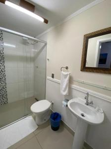 a bathroom with a sink and a toilet and a shower at Hotel Colonial in Pôrto Ferreira
