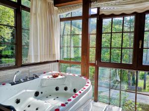 Habitación con ventanas y baño con bañera grande. en Akla La Casa Del Puente, en Regules