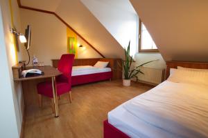 a bedroom with a bed and a desk and a bed and a table at Hotel Deutsches Haus in Hammelburg