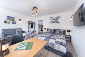 a bedroom with a bed and a table and a couch at FeWo Allgäuliebe mit WLAN Oberstaufen Steibis in Oberstaufen