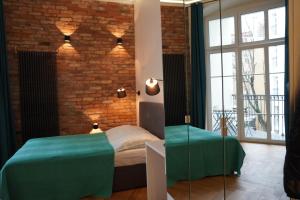 a bedroom with a green bed and a brick wall at My Place in Poznan Centrum in Poznań