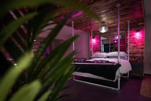 a bedroom with two beds with pink lights at 31B Urban Stays in Norwich