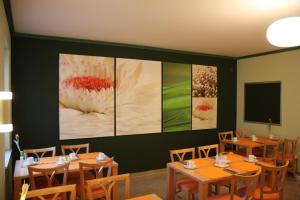 a restaurant with wooden tables and paintings on the wall at Hotel Deutsches Haus in Hammelburg