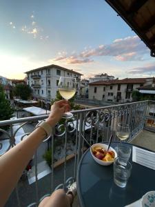 a person holding a glass of wine on a balcony at Nel cuore di Stresa in Stresa