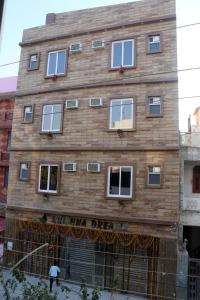 a brown brick building with white windows at Krishna Dreams in Haridwār