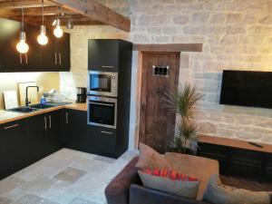 a living room with a couch and a kitchen at Gîte Les Hauts de Morey - Aux Bonnes-Mares in Morey-Saint-Denis