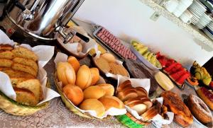 a table topped with baskets of bread and pastries at Pousada Vale Verde in Monte Verde