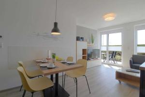 een eettafel en stoelen in de woonkamer bij de Seeduewel Carna 101 in Dorum Neufeld