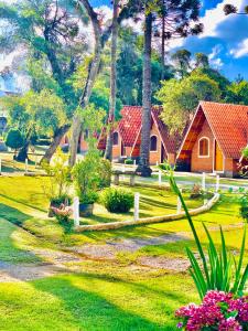 uma casa num parque com árvores e flores em Pousada Vale Verde em Monte Verde