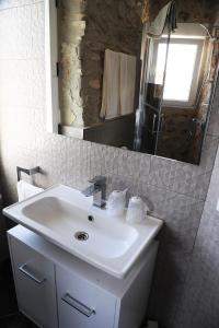 y baño con lavabo blanco y espejo. en Pension Subirats Perello, en Perelló