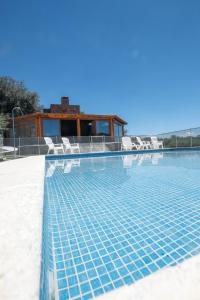 - une piscine avec des chaises et une maison dans l'établissement CABAÑA SOL finca Pu Duam, à Villa General Belgrano