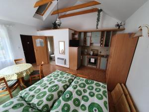 a bedroom with a bed and a kitchen with a table at Dom Colonia in Żarnowska