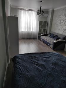 a living room with a bed and a couch at Апартаменти Люкс2 in Khmelʼnytsʼkyy