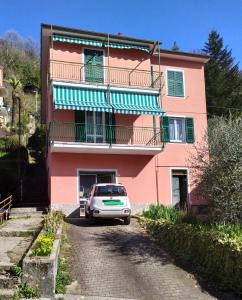 a car parked in front of a pink building at Casa Iris in Borzonasca