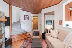 惠斯勒Rainbow by Outpost Whistler的客厅里有一张沙发和一台电视