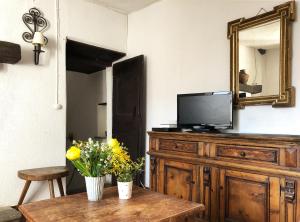 a living room with a television on a wooden dresser at Casa al Vento in Bidogno
