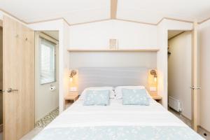 a bedroom with a large bed with two blue pillows at Lilly Pad in South Cerney +49 photos