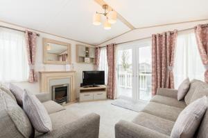 a living room with a couch and a television at Lilly Pad in South Cerney