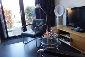 a living room with a chair and a television at Arthouse Dordrecht in Dordrecht